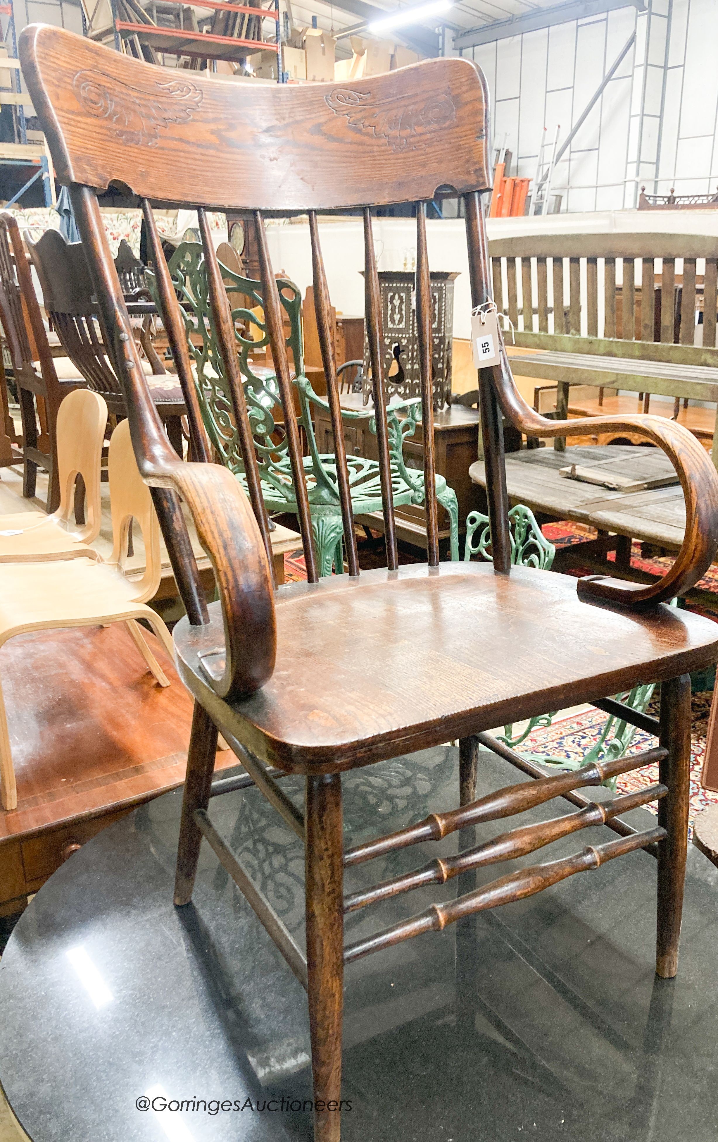 A late Victorian ash and elm comb back elbow chair